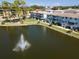 Scenic view of condo building overlooking a beautiful lake with a fountain in a park-like setting at 8181 Eagles Park N Dr, St Petersburg, FL 33709