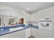 The kitchen has white cabinets and is open to the dining area with a view to the outside at 8181 Eagles Park N Dr, St Petersburg, FL 33709