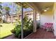Relaxing screened-in patio with red brick pavers, lush plants, and comfortable seating at 8181 Eagles Park N Dr, St Petersburg, FL 33709