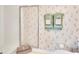 Close up on a shower, toilet, and towels in bathroom with floral wallpaper at 8181 Eagles Park N Dr, St Petersburg, FL 33709