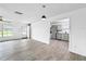 Open living room with sleek gray flooring and an entrance to the updated kitchen at 8451 81St Way, Seminole, FL 33777