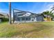 The backyard has a screened-in pool, a patio with seating, and a lake view. It blends outdoor enjoyment with relaxation at 8638 Chadwick Dr, Tampa, FL 33635