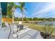 Outdoor seating area on a large patio with lake views and tall palm trees offer a tranquil escape at 8638 Chadwick Dr, Tampa, FL 33635