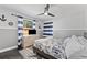 Nautical-themed bedroom featuring light gray walls, blue and white striped curtains, and modern ceiling fan at 8638 Chadwick Dr, Tampa, FL 33635