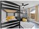 Bedroom with black bunk beds, yellow accents, a modern ceiling fan, and natural light at 8638 Chadwick Dr, Tampa, FL 33635
