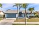 Charming single-story home featuring a well-maintained front yard with palm trees and an attached two-car garage at 8638 Chadwick Dr, Tampa, FL 33635