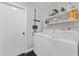 Functional laundry room with washer, dryer, and shelving for storage at 8638 Chadwick Dr, Tampa, FL 33635