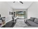 This home office includes modern furniture, a sofa, and sliding glass doors to the lanai at 8638 Chadwick Dr, Tampa, FL 33635