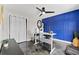 Bright office features a modern desk, unique blue accent wall, and stylish ceiling fan at 8638 Chadwick Dr, Tampa, FL 33635