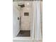 Modern shower featuring gray marble tile, a dark tile floor, and a rainfall shower head at 8638 Chadwick Dr, Tampa, FL 33635