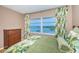 Bright bedroom featuring a large window with water views and stylish, leaf-patterned curtains and bedding at 100 Bluff View Dr # 514C, Belleair Bluffs, FL 33770