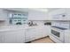 Bright, all-white kitchen features modern appliances, ample countertop space, and a garden view at 100 Bluff View Dr # 514C, Belleair Bluffs, FL 33770