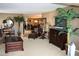 Comfortable living room with dark wood furnishings and an abundance of indoor plants at 100 Bluff View Dr # 514C, Belleair Bluffs, FL 33770