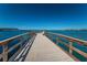 A long pier stretches over blue water in a tranquil setting for waterfront relaxation and leisure at 100 Bluff View Dr # 514C, Belleair Bluffs, FL 33770