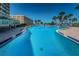 Beautiful pool area featuring ample lounge chairs and lush greenery with condo in background at 100 Bluff View Dr # 514C, Belleair Bluffs, FL 33770