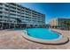 Relaxing pool area with comfortable lounge chairs and well-maintained brick patio next to a multi-story building at 100 Bluff View Dr # 514C, Belleair Bluffs, FL 33770