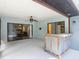 Covered lanai with wood bar, ceiling fan, white flooring, and sliding glass doors to the interior at 1014 Sylvia Ln, Tampa, FL 33613