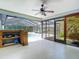 Enclosed lanai featuring a ceiling fan, white flooring, sliding glass doors and a lake view at 1014 Sylvia Ln, Tampa, FL 33613