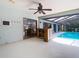 Covered lanai with wood bar, ceiling fan, white flooring, and sliding glass doors to the interior and pool at 1014 Sylvia Ln, Tampa, FL 33613