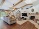 Cozy living room showcasing a fireplace with exposed brick, wood beams, and comfortable seating arrangement at 1014 Sylvia Ln, Tampa, FL 33613