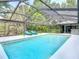 Inviting pool surrounded by a screened enclosure with comfortable lounge chairs for sunny relaxation and leisure at 1014 Sylvia Ln, Tampa, FL 33613