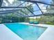 Sparkling screened-in pool with outdoor lounge chairs and a beautiful view of the clear blue sky at 1014 Sylvia Ln, Tampa, FL 33613
