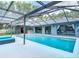 Sparkling pool with a screened enclosure, a bar, and backyard access for entertaining and relaxation at 1014 Sylvia Ln, Tampa, FL 33613