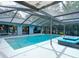 Sparkling screened-in pool with outdoor lounge chairs and a view of the home at 1014 Sylvia Ln, Tampa, FL 33613