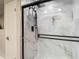 Elegant walk-in shower with modern fixtures and stylish marble-look tiling at 1014 Sylvia Ln, Tampa, FL 33613
