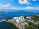 Gorgeous aerial view showcasing bay access, meticulous landscaping, and modern building design at 1020 Sunset Point Rd # 410, Clearwater, FL 33756