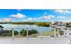 Bright condo balcony overlooking water, showcasing seamless glass railings and tile floor at 1020 Sunset Point Rd # 410, Clearwater, FL 33756
