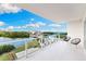 Condo balcony with water views, featuring sleek white tile and modern seating at 1020 Sunset Point Rd # 410, Clearwater, FL 33756