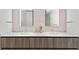 Bathroom with double sinks, modern faucets, and wood-grain cabinets at 1020 Sunset Point Rd # 410, Clearwater, FL 33756