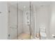 Modern bathroom featuring a glass-enclosed shower with a rain shower head and a toilet at 1020 Sunset Point Rd # 410, Clearwater, FL 33756
