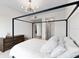 Modern bedroom with a canopy bed and a glimpse into an ensuite bathroom at 1020 Sunset Point Rd # 410, Clearwater, FL 33756