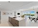 Bright, open-concept kitchen features a large island and modern appliances, flowing into the living space with water views at 1020 Sunset Point Rd # 410, Clearwater, FL 33756
