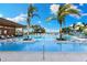 Stunning pool area with palm trees, lounge chairs, and ocean views at 1020 Sunset Point Rd # 410, Clearwater, FL 33756