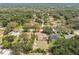 An aerial view showcasing this home's back yard and screened-in lanai, near surrounding houses and nature at 10306 Shalimar Wood Dr, Thonotosassa, FL 33592