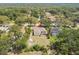 Aerial view of a home with a screened in patio, surrounded by lush trees and landscape at 10306 Shalimar Wood Dr, Thonotosassa, FL 33592