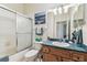 Bathroom with a shower/tub combo, blue countertop, and wood-look cabinets at 10306 Shalimar Wood Dr, Thonotosassa, FL 33592