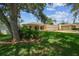 Charming single-story home with a three-car garage, landscaped yard, and inviting front porch at 10306 Shalimar Wood Dr, Thonotosassa, FL 33592