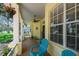 Relaxing front porch with blue chairs, decorative welcome sign, and ample natural light at 10306 Shalimar Wood Dr, Thonotosassa, FL 33592