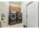 Efficient laundry room with modern washer and dryer, storage cabinets, and tile flooring at 10306 Shalimar Wood Dr, Thonotosassa, FL 33592