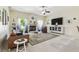 Bright living room with a fireplace, ceiling fan, comfortable seating, and large windows at 10306 Shalimar Wood Dr, Thonotosassa, FL 33592