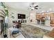 Bright open-concept living room connected to the kitchen, featuring a ceiling fan and modern entertainment center at 10306 Shalimar Wood Dr, Thonotosassa, FL 33592