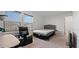 Bright bedroom featuring a plush bed, recliner, and neutral decor at 10448 Ladybug Cv, Parrish, FL 34219