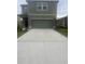 Two-story home featuring a large driveway and a two-car garage at 10448 Ladybug Cv, Parrish, FL 34219