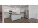 Modern kitchen with white cabinetry, granite countertops, stainless steel appliances, and hardwood floors at 10448 Ladybug Cv, Parrish, FL 34219