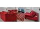 Bright living room with red furniture, rug, and a large television for entertainment at 10448 Ladybug Cv, Parrish, FL 34219