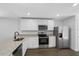 A well-lit kitchen showcasing white cabinets, granite countertops, and stainless steel appliances at 11199 Murraysville Dr, Spring Hill, FL 34609